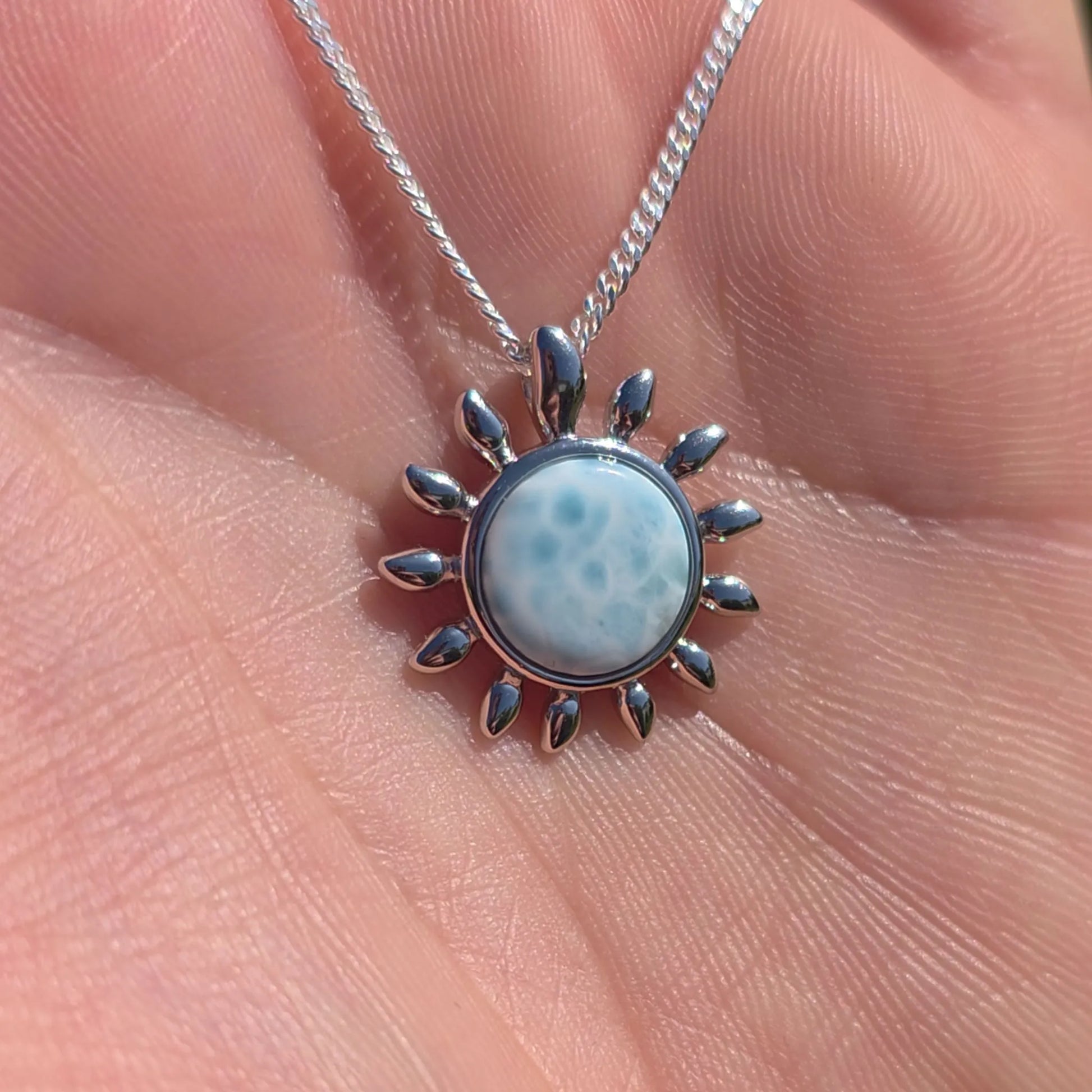 Larimar Sonnen Anhänger in der Hand – natürlicher Larimar Edelstein aus der Karibik in 925 Silber gefasst
