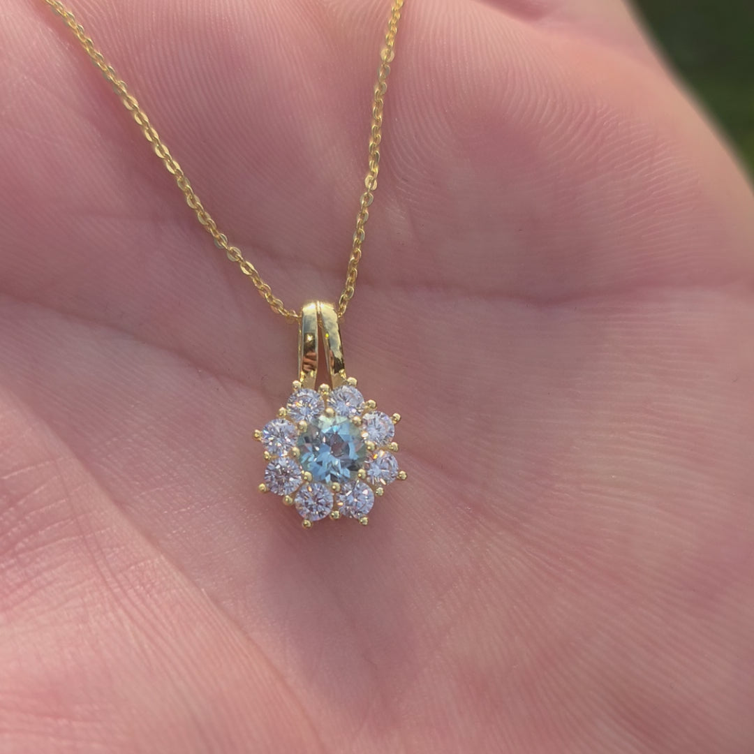 Vergoldetes 925er Silber Collier mit echtem blauen topas, der im Sonnenlicht funkelt. Nahaufnahme der Kette im natürlichem Licht